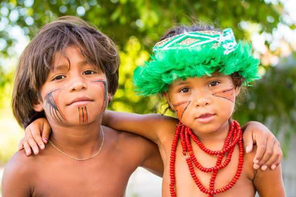 portrait de deux enfants de la tribu Pataxós avec des peintures traditionnelles rouge et noir sur le visage au Brésil.