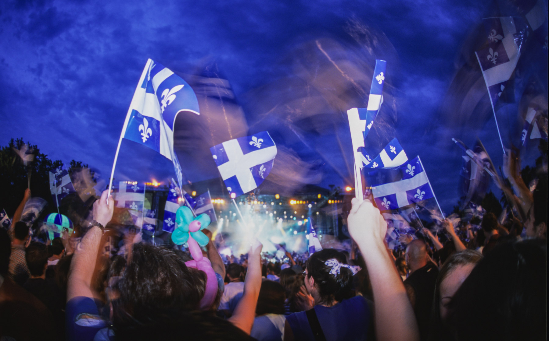 De nombreux drapeaux bleus et blanc sont agités dans les airs par la foule lors de la fête nationale du Québec.