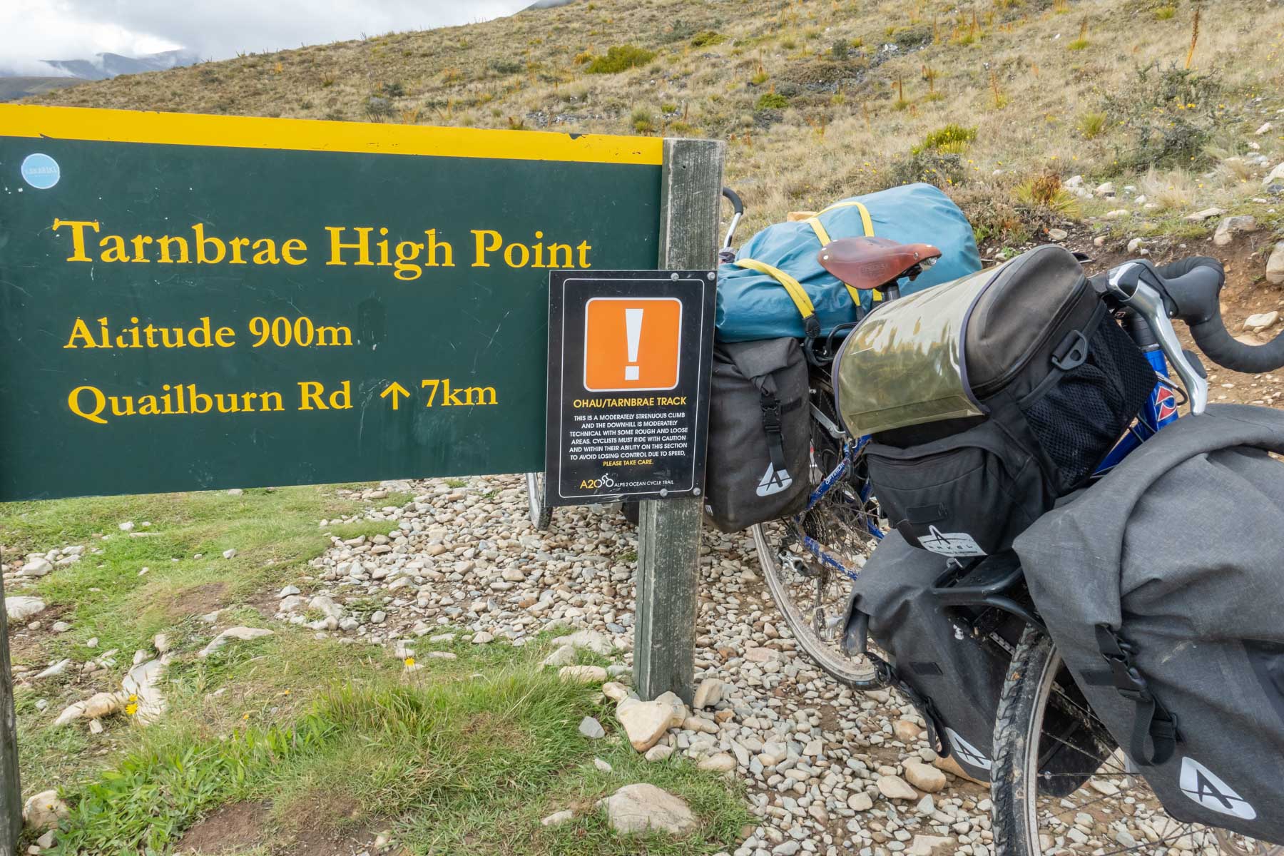 Un panneau indique le sommet de la piste cyclable à 900 mètres d’altitude.