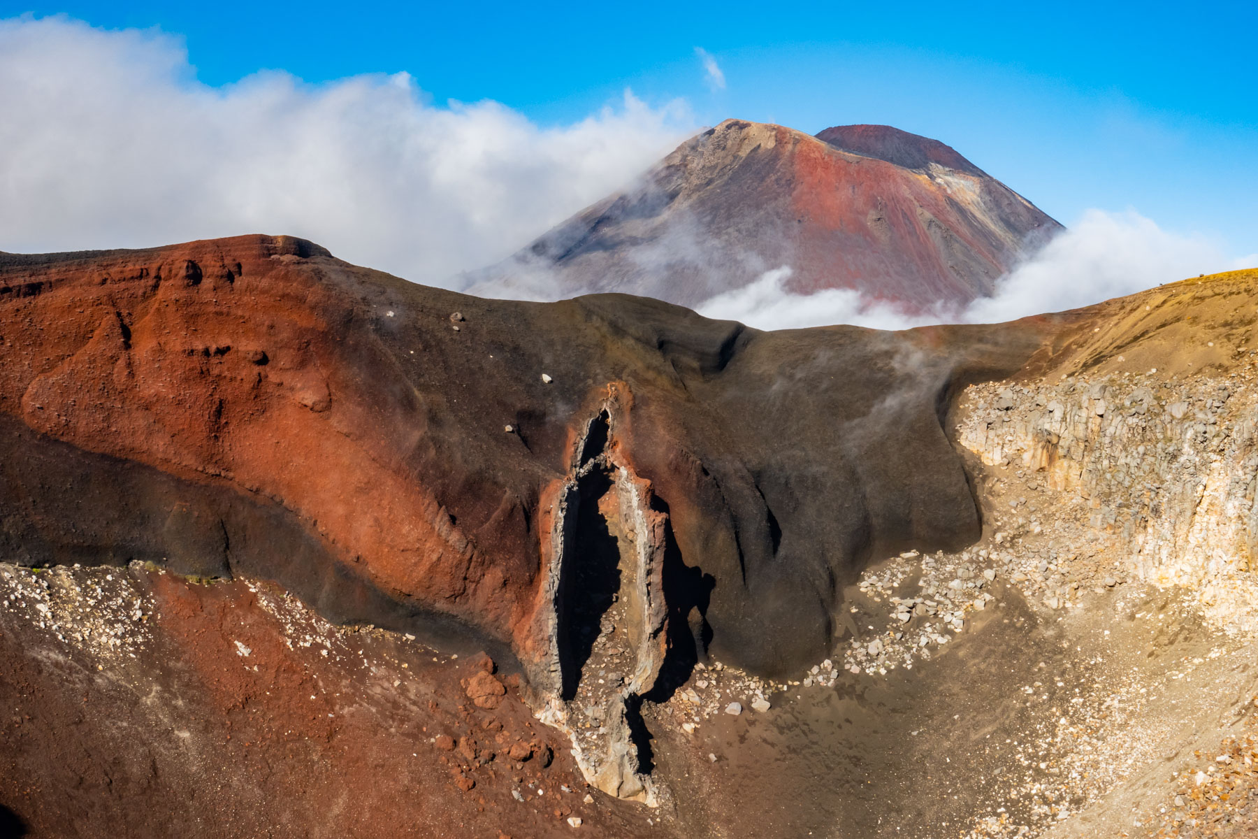 Impressionnant paysage rouge avec une curieuse formation rocheuse et le cratère du volcan Ngauruhoe.
