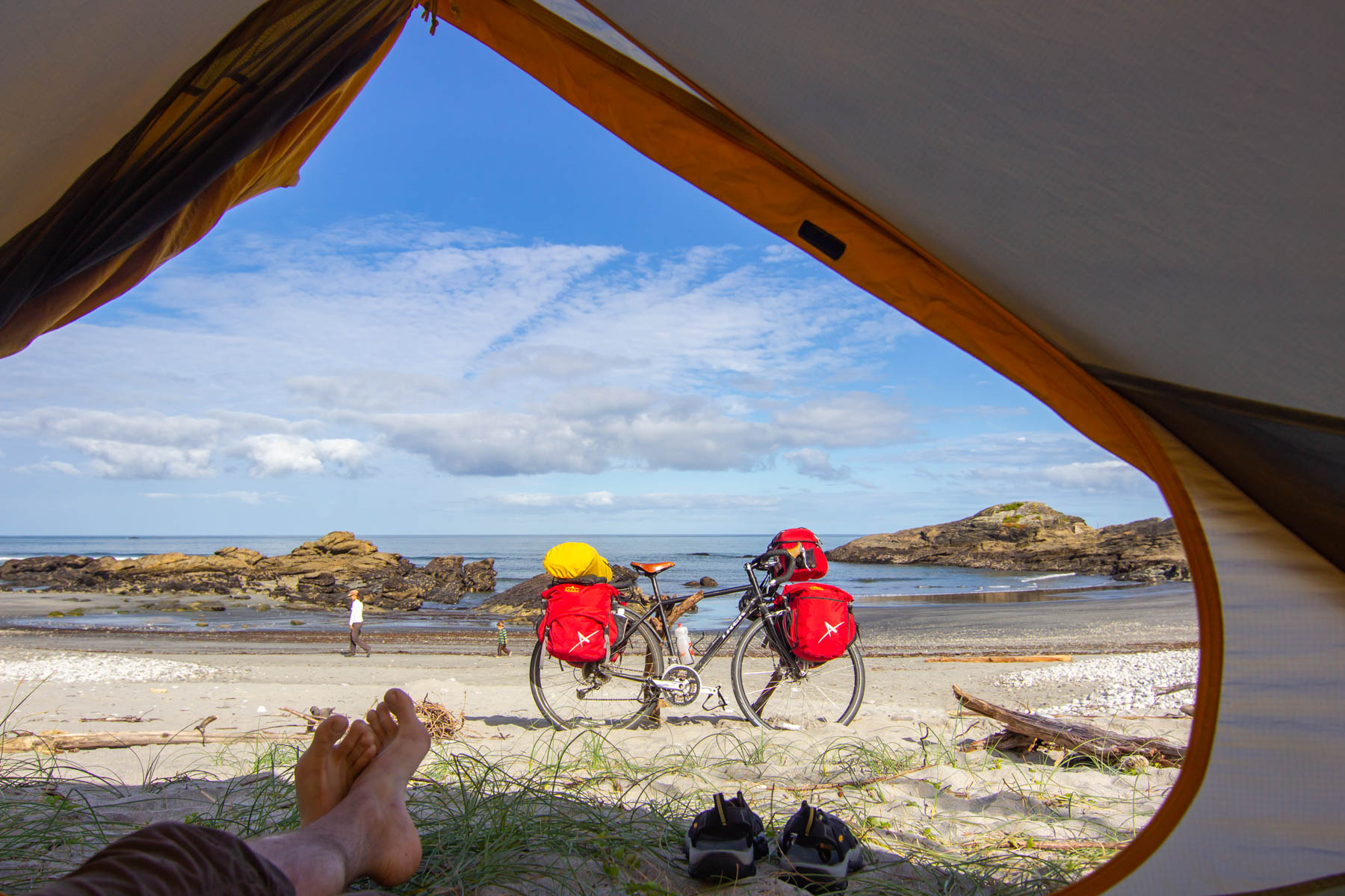 Sandy beach at low tide and bicycle touring seen from inside a tent.